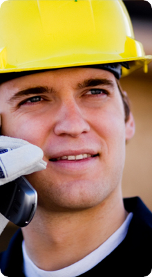 man met telefoon en bouwhelm